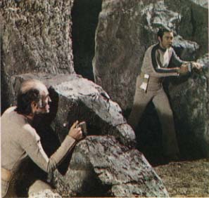 Victor and John crouching behind rocks