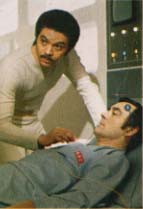 Dr. Vincent bending over the unconscious Commander Koenig