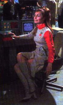 Catherine Schell seated at Maya's console in Command Center